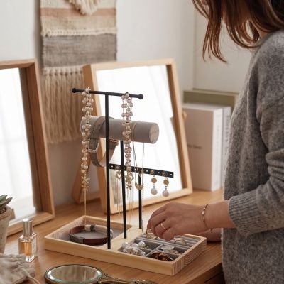 Femme debout range ses bijoux dans Porte bijoux poser sur la coiffeuse