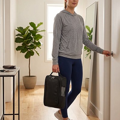 Femme tient en main Sac à chaussures en train d ouvrir la porte