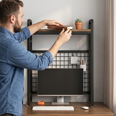 Homme debout etale ses livres sur Etagere bureau noir