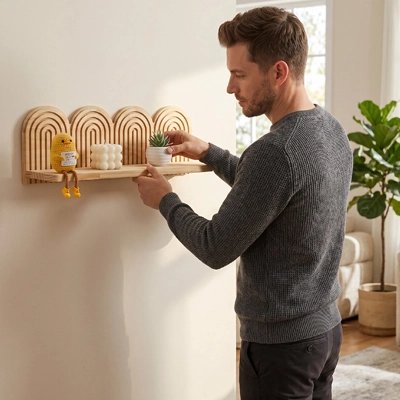 Homme pose pot de fleur sur Etagere bois