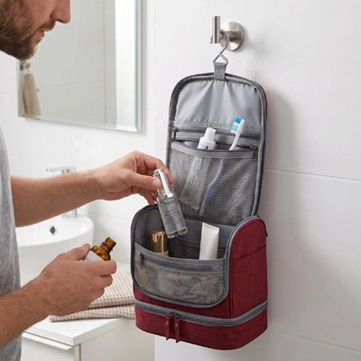 Homme range sa lotion dansTrousse de toilette accrocher au mur