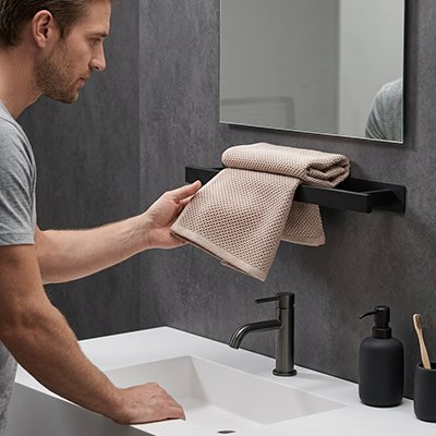  Homme tenant une serviette etalee sur porte serviette 