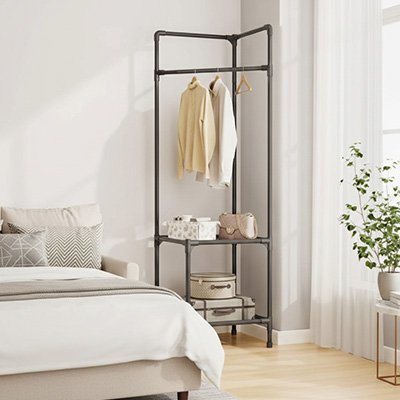 Porte vetement  placer a l angle dans chambre avec vetements et sac a main par dessus