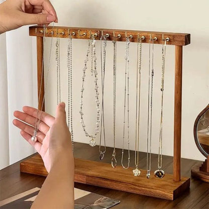 Une main accroche bijoux sur Porte bijoux en bois massif